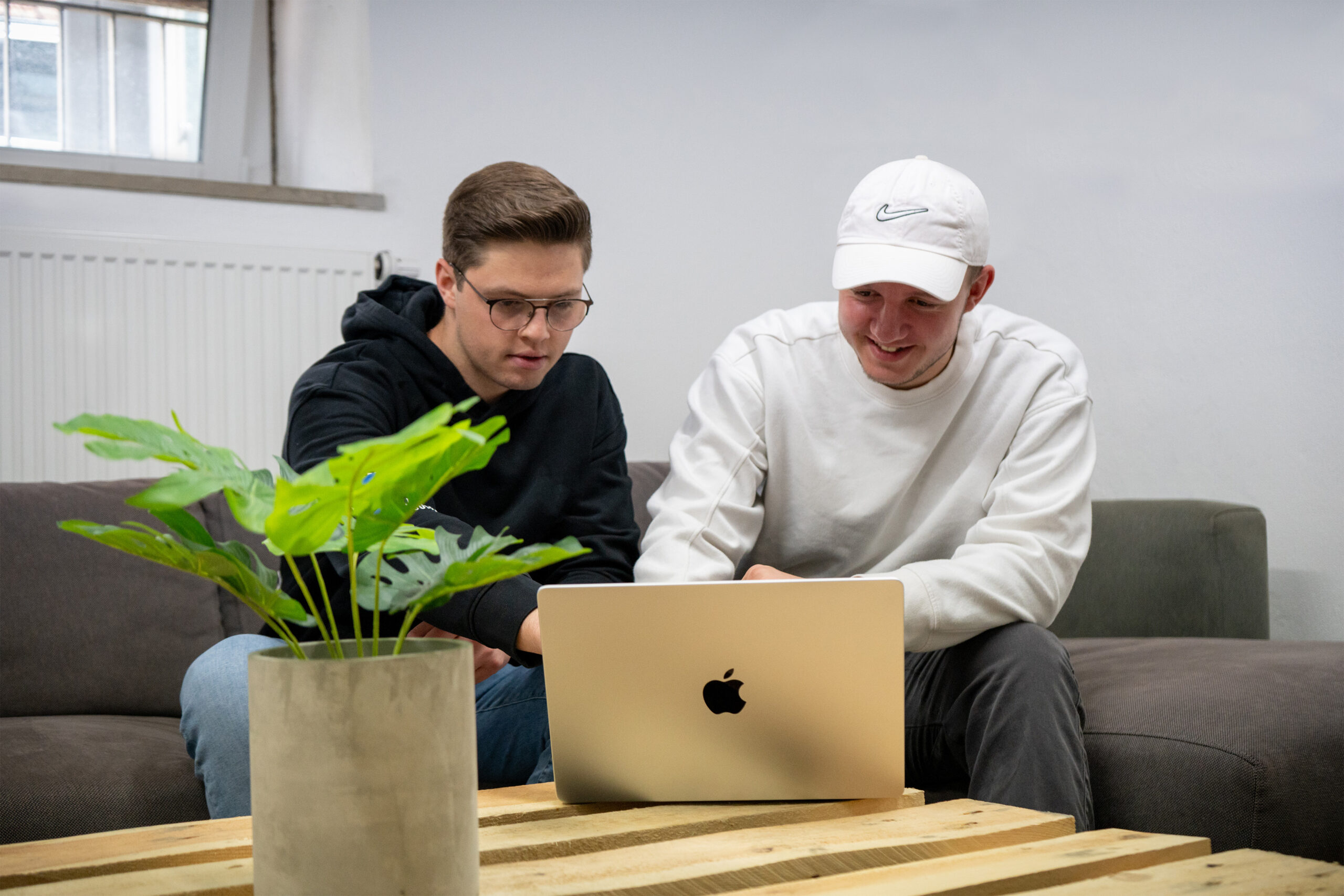 Bild von Nico Werner und Elias Krapf blicken auf ein MacBook